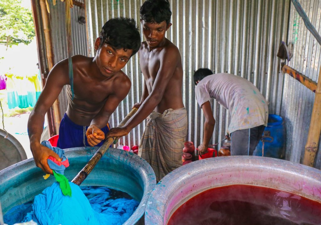 Children working with toxic chemicals to produce dye for clothing.