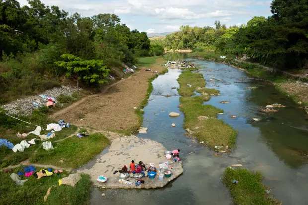 Women wash laundry along the Meille River, a tributary to the Artibonite River. This is the longest waterway in Haiti, which carried cholera through the country.